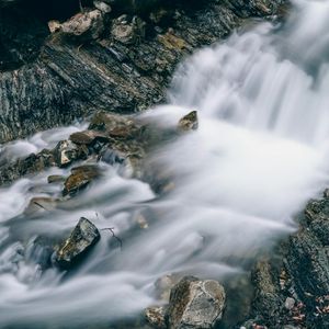 Water flowing smoothly over stones in a stream.